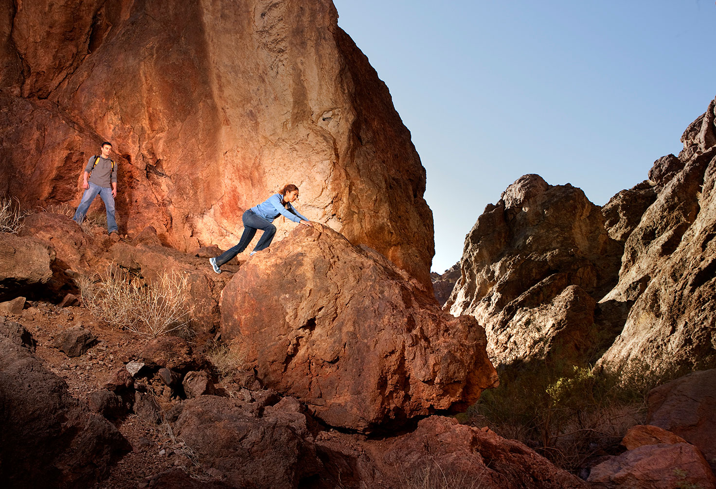 Friends hiking up mountain side, Valley of Fire State Park