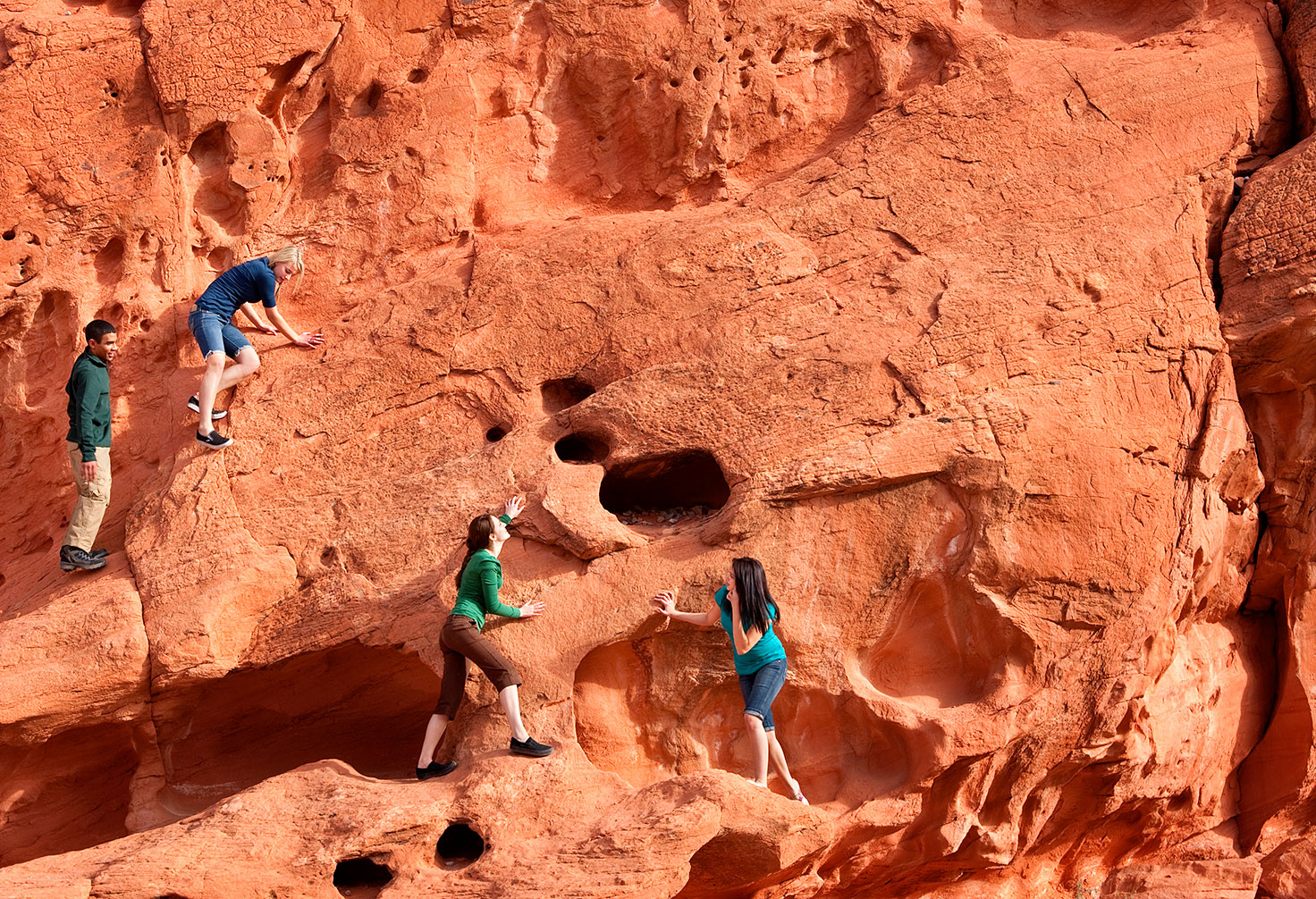 Friends hiking up mountain side, valley of fire state park nevada